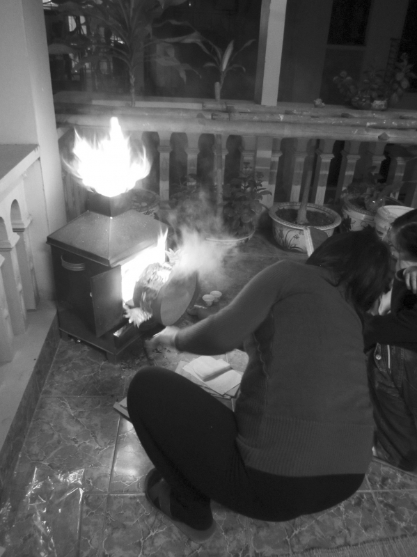 Fête du Têt chez des particuliers brûlant des vêtements pour le génie tutélaire de la maison, Hanoï, 22 janvier 2012. 